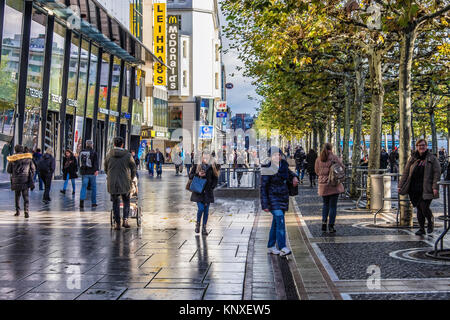 Commerciale di Zeil promenade, Francoforte, Germania.Shppers camminando lungo lastricata strada pedonale piena di negozi,pavimentazione decorativa,alberi sfoltiti. Foto Stock