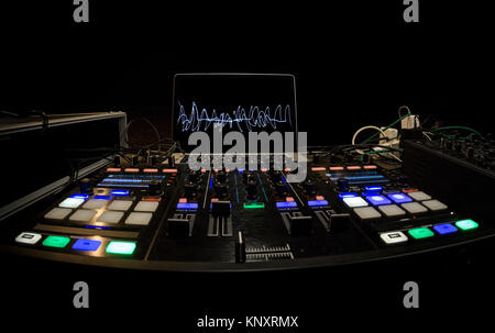 Il dj utilizza una console di mixaggio e pc portatile per gestire la musica elettronic. Foto Stock