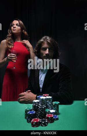 L uomo alla roulette tavolo circondato da belle donne Foto Stock