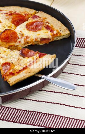 Un vicino la porzione di una squisita pizza Foto Stock