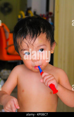 Kid boy spazzolatura dei denti e sorridente Foto Stock