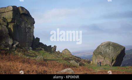 Due persone ammirando la vacca e vitello rocce vicino a Ilkley, West Yorkshire. Foto Stock