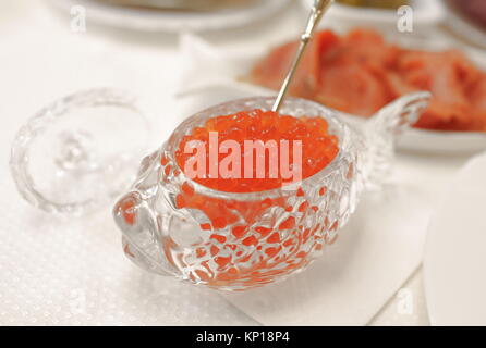 Caviale rosso in una ciotola di cristallo con salmone closeup Foto Stock