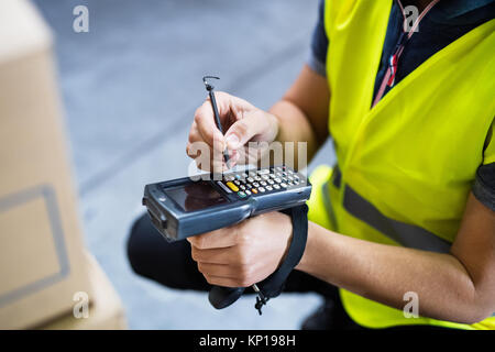 Magazzino maschio lavoratore con uno scanner di codici a barre. Foto Stock