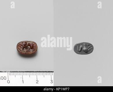 Piccolo scarabeo carneliano etrusco del III secolo a.C., 1 x 1,4 cm, utilizzato come sigillo o amuleto, scolpito in pietra carneliana rossa-arancione. Foto Stock