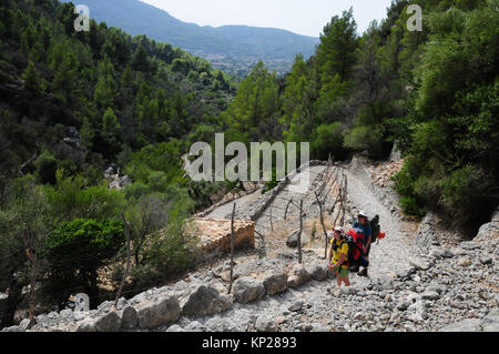 Due escursionisti salire le montagne Tramuntana in Mallorca sulla GR221 Ruta de Pedra en Sec a lunga distanza percorso. Questo è il Barranc de Biniaraix. Foto Stock