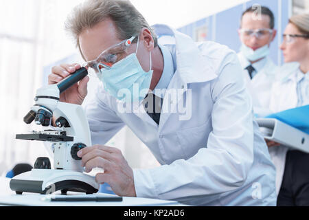 Scienziato che lavora con il microscopio Foto Stock