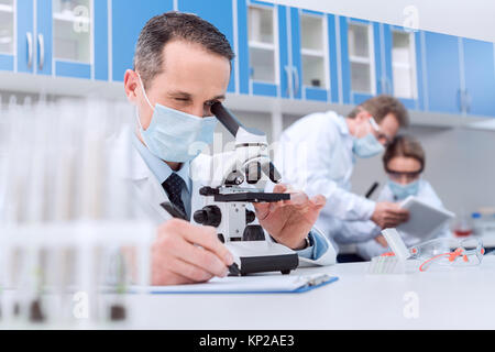 Scienziato che lavora con il microscopio Foto Stock