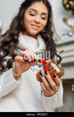 Donna che mantiene la candela decorata con cannella Foto Stock