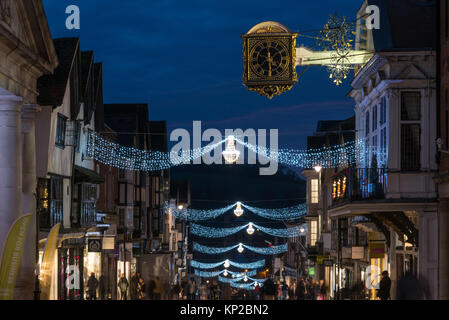 La High Street in Guildford con luci di Natale e la famosa Guildhall orologio in oro in blu ora su una notte tarda giornata di shopping, England Regno Unito Foto Stock