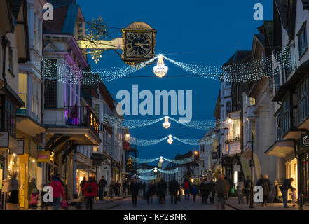 La High Street in Guildford con luci di Natale e la famosa Guildhall orologio in oro in blu ora su una notte tarda giornata di shopping, England Regno Unito Foto Stock