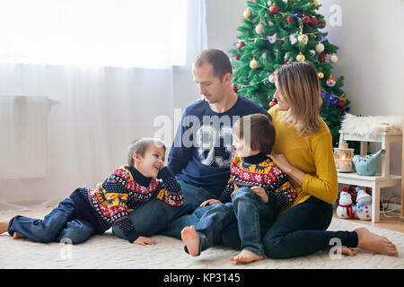 La famiglia felice avendo divertimento a casa natale ritratto di famiglia nella parte anteriore dell'albero di Natale Foto Stock