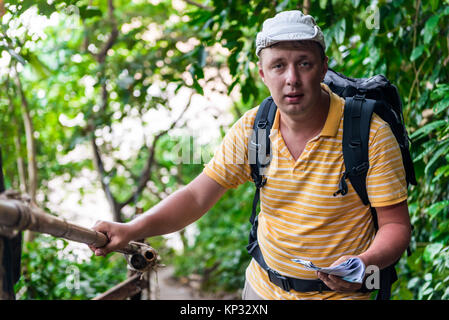 Turismo a maschio con lo zaino nella giungla in appoggio Foto Stock