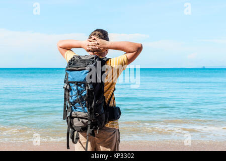 Una vacanza con una vista mare - un turista con lo zaino si ammira il mare Foto Stock