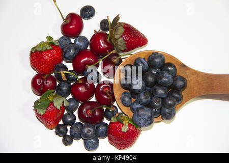 Frutti rossi su sfondo bianco e il cucchiaio di legno Foto Stock