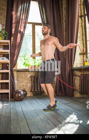 Vista dell'uomo facendo allenamento cardio con salto con la corda. Foto Stock