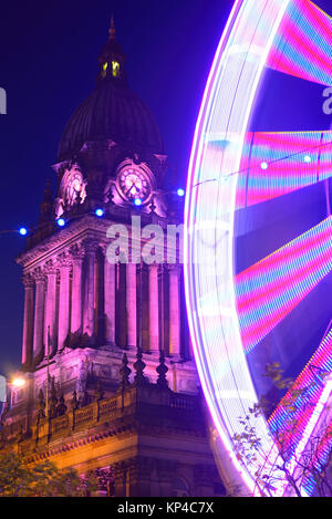 Il traffico che passa luna park e le luci di Natale da leeds town hall al crepuscolo Yorkshire Regno Unito Foto Stock