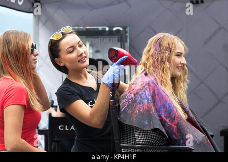 Vancouver, Canada - Agosto 31th, 2017: una donna parrucchiere promuovere prodotti Clairol la tintura dei capelli di un cliente esterno. Foto Stock