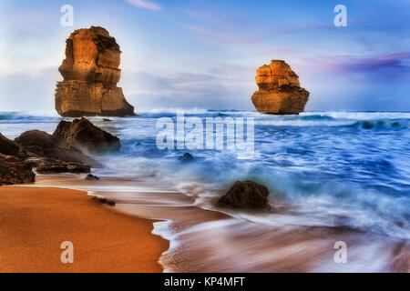 Due apostless off Gibson passi spiaggia a sunrise di surf di onde che si infrangono scogliere calcaree e rocce - parte dei famosi dodici apostoli parco marino su G Foto Stock