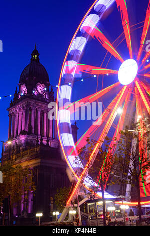 Il traffico che passa luna park e le luci di Natale da leeds town hall al crepuscolo Yorkshire Regno Unito Foto Stock