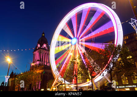 Il traffico che passa luna park e le luci di Natale da leeds town hall al crepuscolo Yorkshire Regno Unito Foto Stock