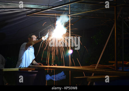 Putrajaya, Malesia - 12 Giugno 2012 : uomo asiatico facendo qualche lavoro di saldatura di notte.Il lavoro di saldatura Foto Stock