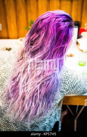 Donna applicando una viola il colore dei capelli shampoo. Foto Stock