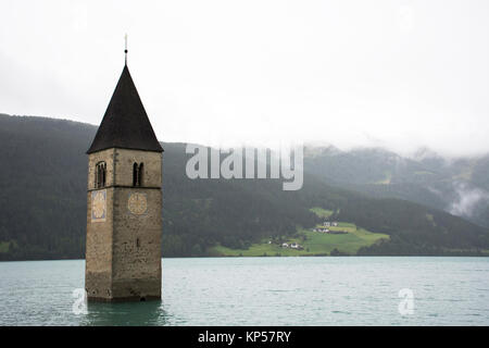 Torre sommersa di reschensee chiesa nel profondo Resias lago mentre piove al mattino in Trentino-Alto valley in Sud Tyr o Alto Adige a Bolzano o boz Foto Stock