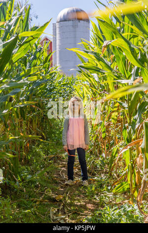 Giovane ragazza che corre giocare nel campo di grano Foto Stock