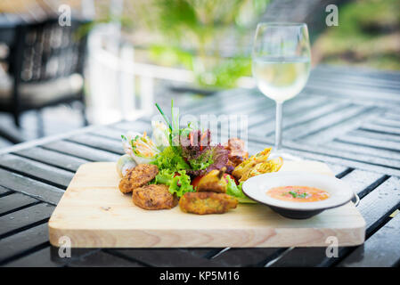 Misto snack asiatico antipasti piatto con involtini primavera, torte di gamberi, insalata e salsa di peperoncino Foto Stock