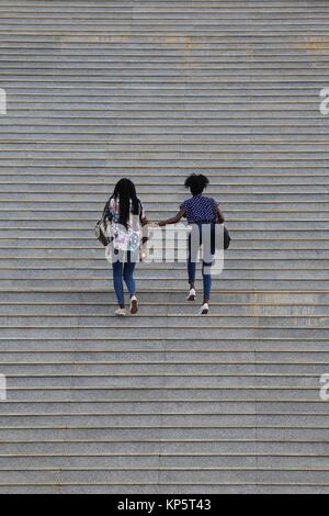 Dinamica di due giovani donne salendo una grande scala in Senegal Foto Stock