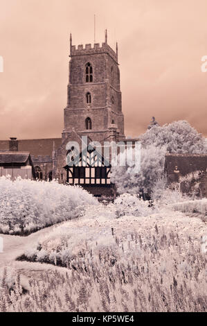 Una immagine infrarossa del National Trust Garden Dream in fiore al Castello di Dunster nel Somerset, Inghilterra con la chiesa di San Giorgio in background Foto Stock