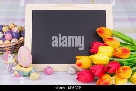 Colorata decorazione di Pasqua con la caramella, tulipani e dipinto di uovo Foto Stock