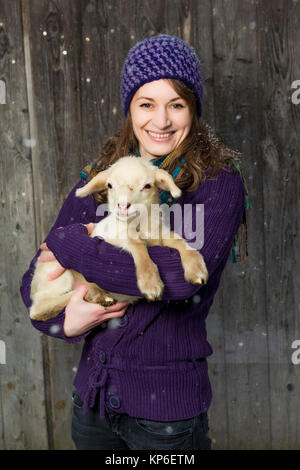 Frau mit Laemmchen bei Schneefall - donna con little lamb Foto Stock