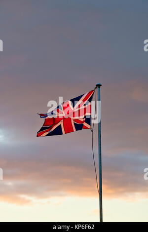 Union Jack flag sbattimenti nel vento al tramonto in Cotswolds. Broadway, Cotswolds, Worcestershire, Inghilterra Foto Stock