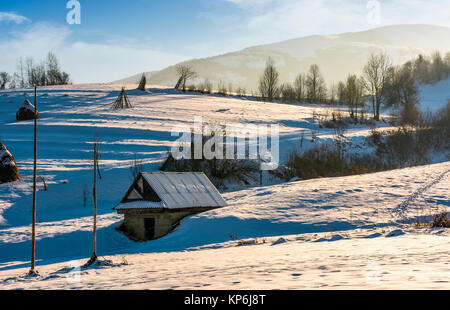Sparso su strade coperte di neve agricolo di collina. incantevole paesaggio rurale in inverno Foto Stock