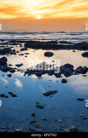 Bellissima mellow tramonto sulla spiaggia rocciosa Foto Stock