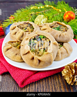 Canti natalizi in piatto con i funghi e le decorazioni di Natale a bordo Foto Stock