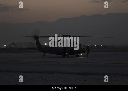 Regolazione del sole non smette di equipaggi da preparandosi a UH-60 Black Hawk elicottero per una missione in Afghanistan il 9 dicembre 2017. L'elicottero e il suo equipaggio sono parte della Task Force Brawler, 4° Battaglione, 3° Reggimento di aviazione, fuori di Savannah, Georgia il supporto di operazioni in Afghanistan settentrionale. (US Army Foto Stock