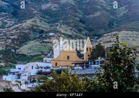 Villaggio con la chiesa di san vincenzo alla base del vulcano Stromboli e le pendici della stessa in background Foto Stock