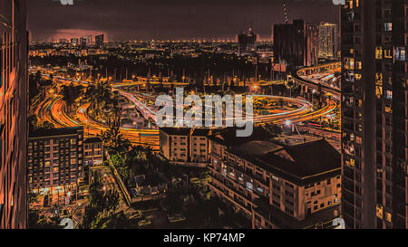 Vista sulla strada fuori di Bangkok con colorate luci di traffico durante le ore di punta di notte da un grattacielo Foto Stock