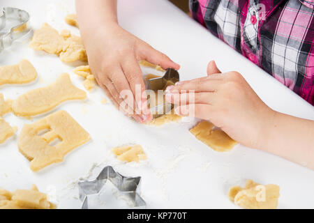 I bambini con le mani in mano impastare la pasta per i biscotti di cottura Foto Stock