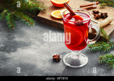 Vin brulé con spezie e albero di Natale su sfondo scuro. Foto Stock