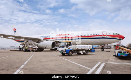 Pechino-Maggio 6, 2014. Aeroplano parcheggiate all'Aeroporto Internazionale Capital di Pechino, al personale di terra con attrezzature occupato con la fornitura e la manutenzione. Foto Stock