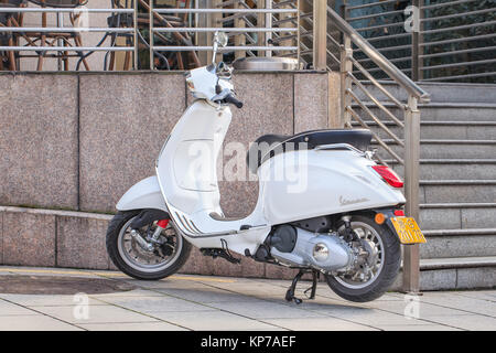 Di YIWU-gen. 15, 2016. White scooter Vespa parcheggiata di fronte una caffetteria. Vespa è un italiano di scooter marchio prodotto dalla Piaggio. Foto Stock