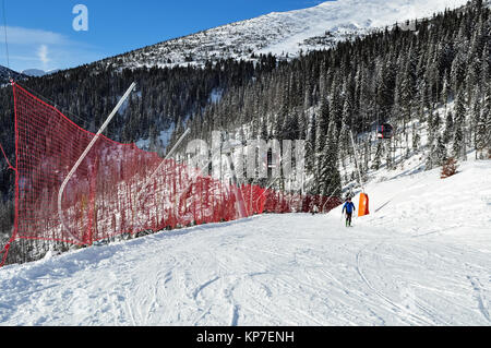 Jasna, Slovacchia - 1 Dicembre 2017: Sciatori sul pendio della montagna e il recinto-griglia sul lato sud del monte Chopok in una giornata di sole in sci Foto Stock