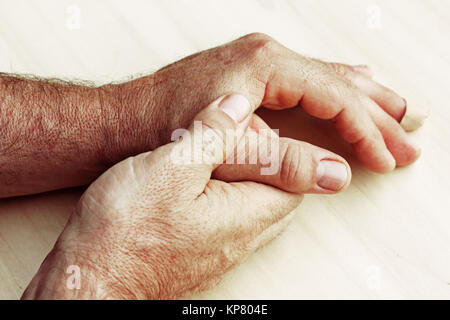 Un uomo anziano ha il dolore in le dita e le mani Foto Stock