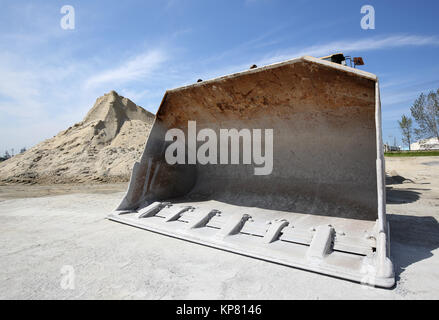 Bulldozer con tumulo di cava contro un cielo blu Foto Stock