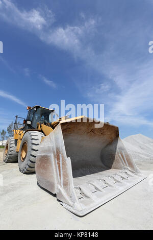 Bulldozer con sabbia mound contro un cielo blu Foto Stock