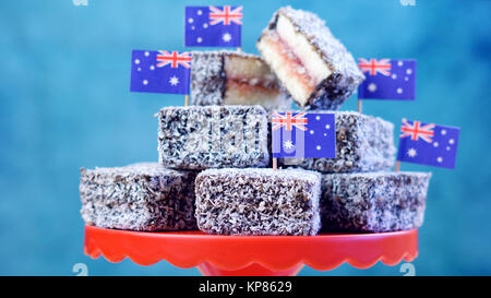 Iconico tradizionale festa australiana cibo, Lamington dolci e pane di fata, su un rosso, bianco e blu. Foto Stock